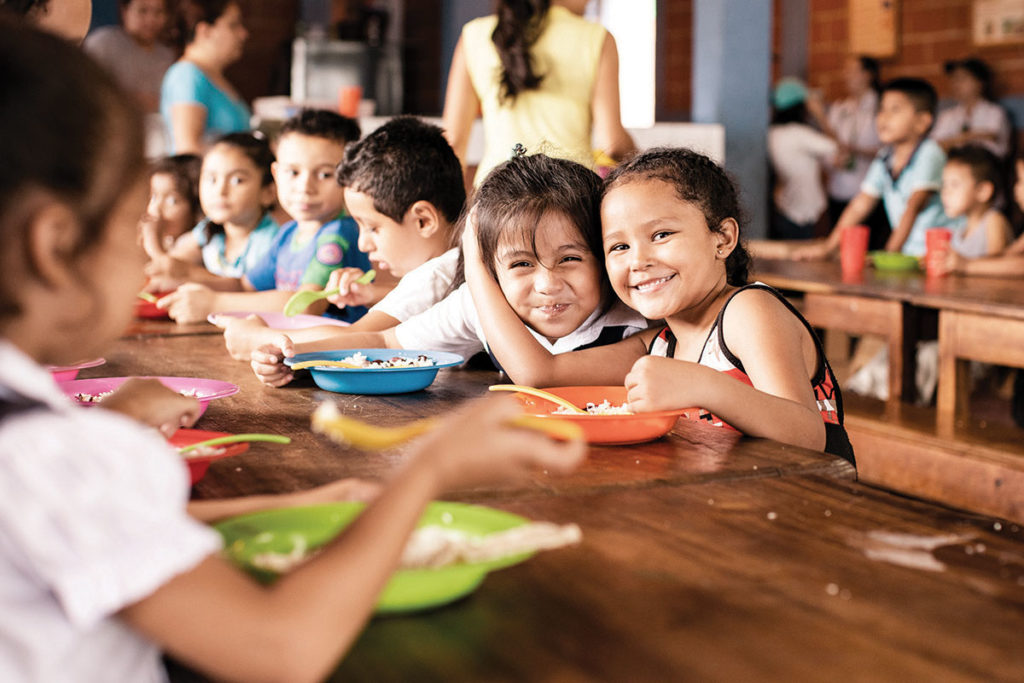 niños disfrutando almuerzo escolar en centro de fabretto